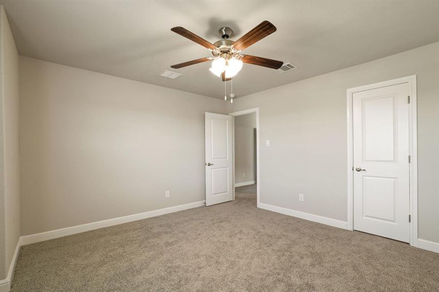 Unfurnished bedroom with carpet flooring and ceiling fan Unfurnished bedroom with carpet flooring and ceiling fan