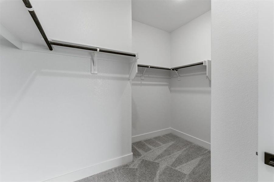 Walk in closet with light carpet