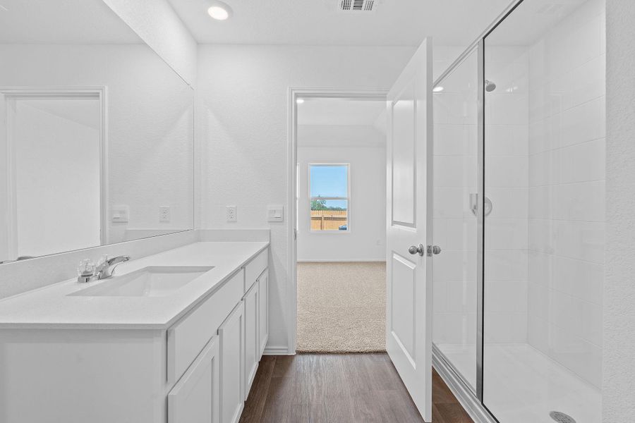 Full bath featuring a stall shower, vanity, and dark wood-style floors Full bath featuring a stall shower, vanity, and dark wood-style floors