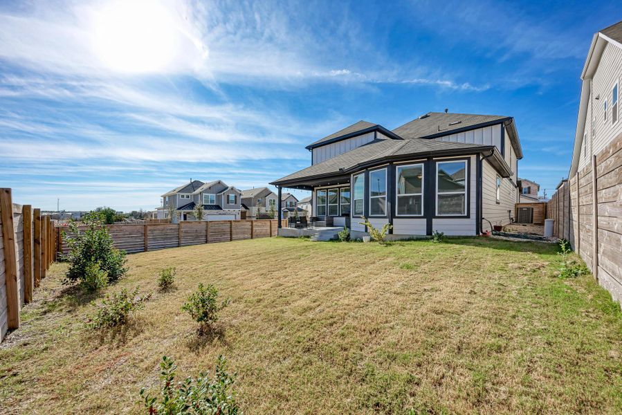 Back of house featuring a fenced backyard, a patio, board and batten siding, and roof with shingles