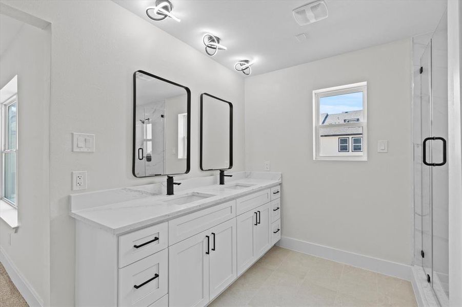 Full bath featuring double vanity and a shower stall