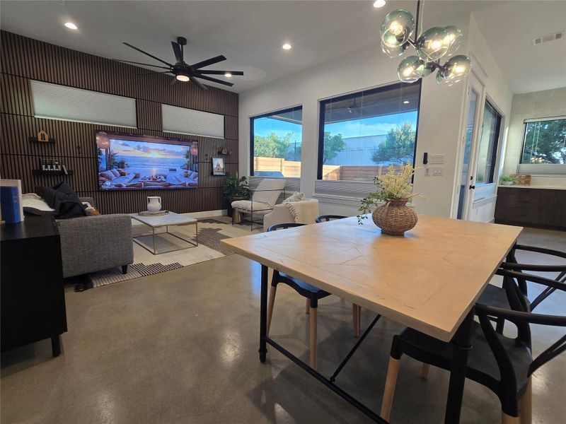 Polished concrete floors and wood panel accents anchor this modern open-concept living space.