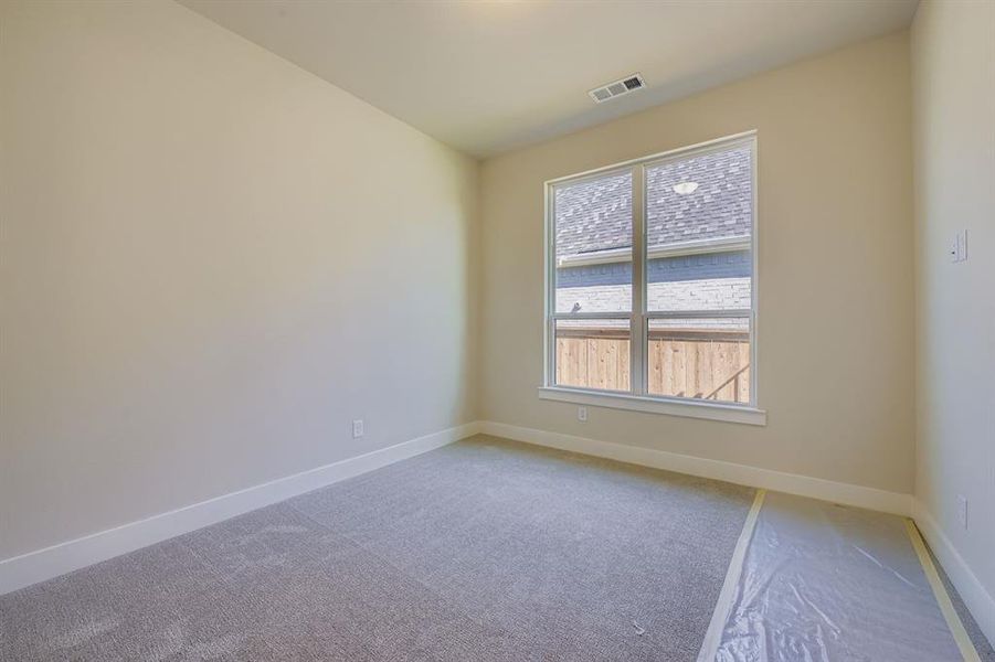 Carpeted spare room with baseboards