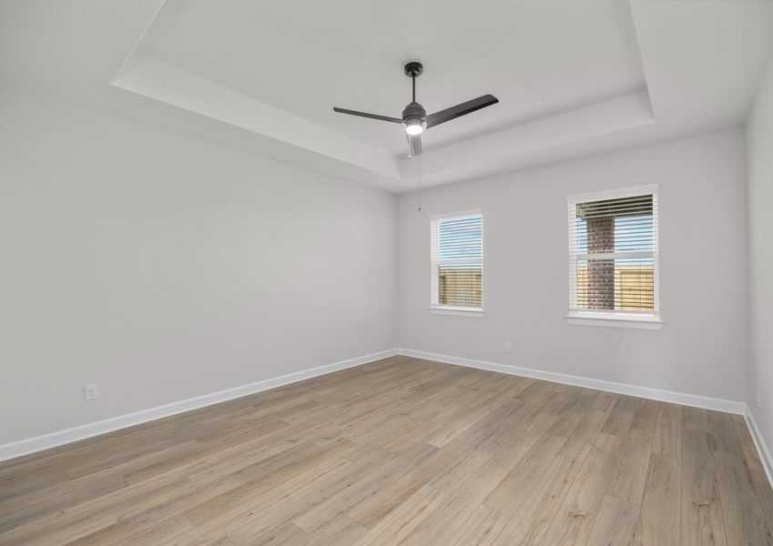 Master bedroom with plank flooring and a ceiling fan