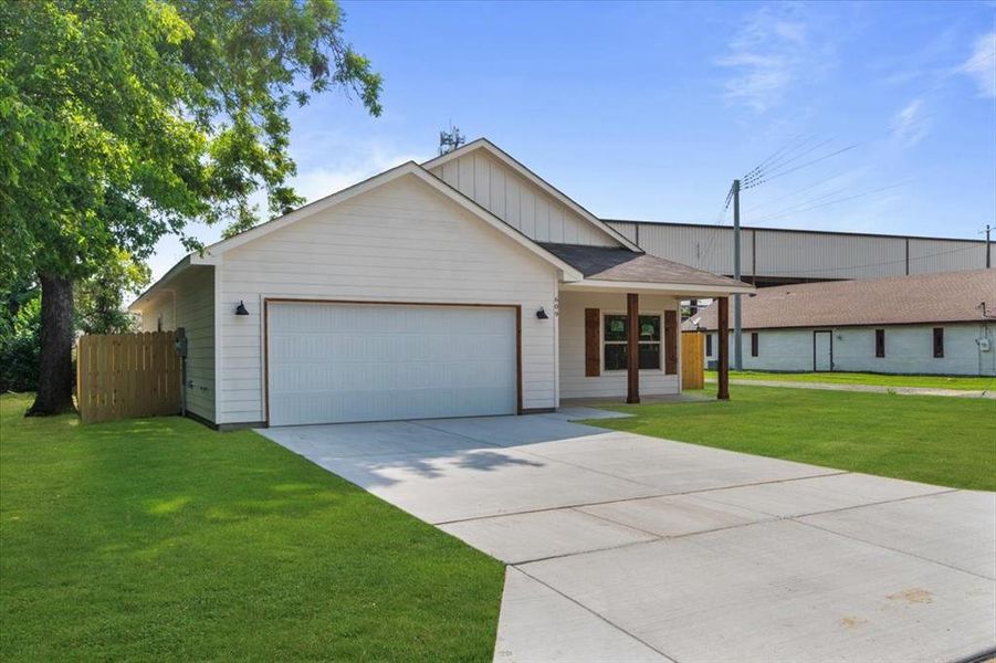 Ranch-style home featuring a garage, a front yard, and covered porch