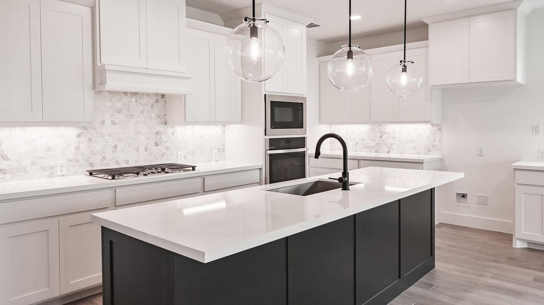 Kitchen with a sink, stainless steel appliances, and white cabinets