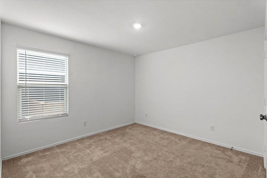 A well-lit room featuring plush carpeting and a window with blinds, offering a versatile living space. A well-lit room featuring plush carpeting and a window with blinds, offering a versatile living space.