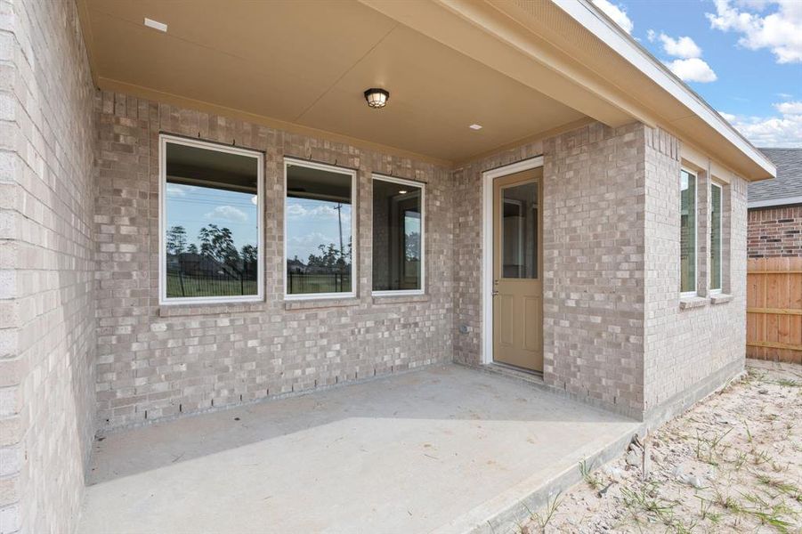 The covered patio is generously sized, providing ample space for various outdoor activities.