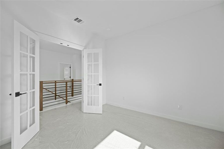 Unfurnished bedroom featuring french doors and carpet Unfurnished bedroom featuring french doors and carpet