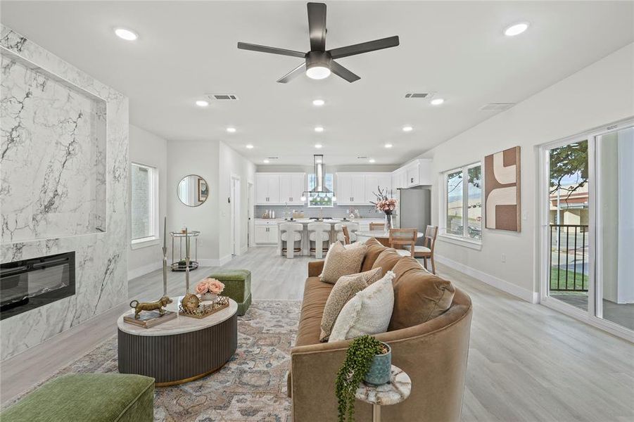 Living area with light wood finished floors, a high end fireplace, a ceiling fan, and recessed lighting Living area with light wood finished floors, a high end fireplace, a ceiling fan, and recessed lighting