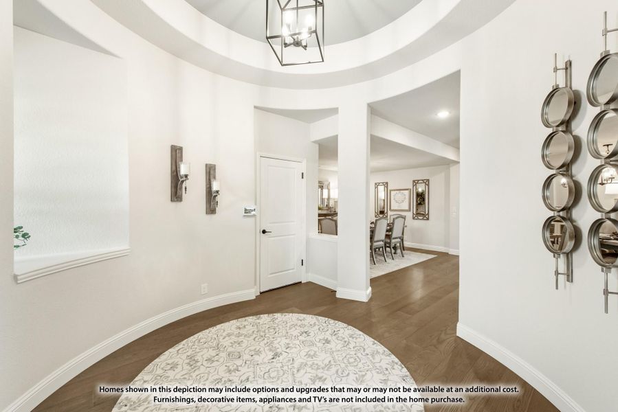 Foyer with circular tray ceiling, pendant light, dark hardwood floors, and round area rug leading to dining room Foyer with circular tray ceiling, pendant light, dark hardwood floors, and round area rug leading to dining room
