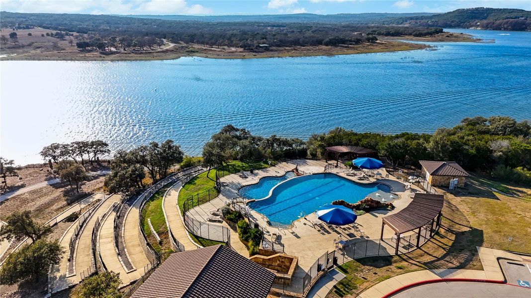 An inviting swimming pool overlooks the serene, wide waters of a picturesque lake. An inviting swimming pool overlooks the serene, wide waters of a picturesque lake.