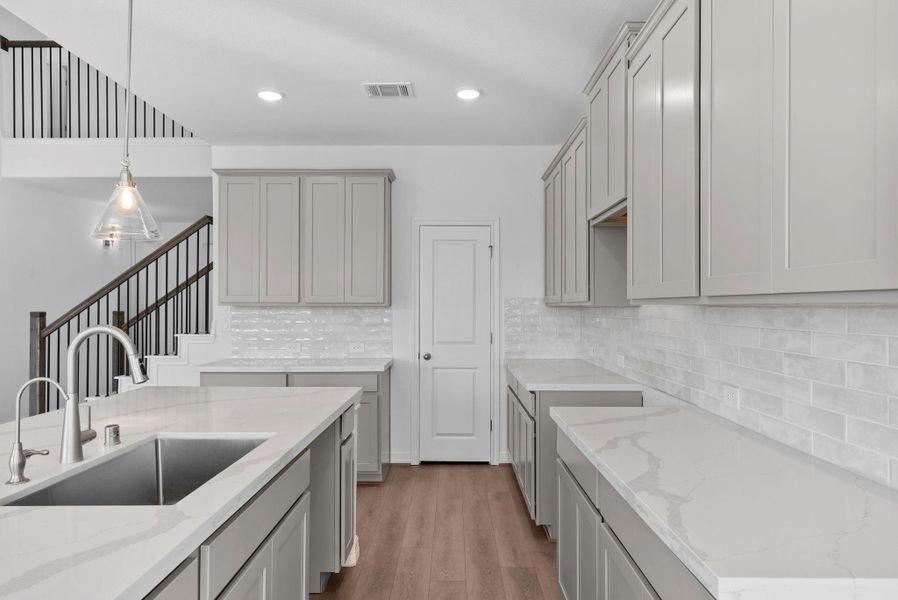 Design-forward kitchen with the AW Collection Milan, highlighted by gray cabinets, modern tile, and an expansive center island.