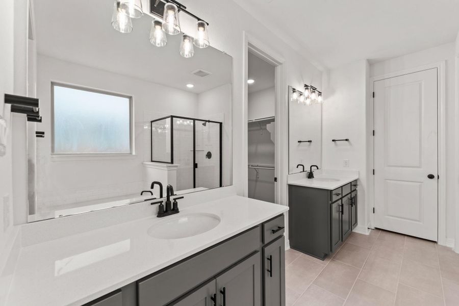 The en-suite bathroom offers a spa-like atmosphere with its elegant design, high end finishes, and tasteful lighting, creating a retreat within your own home.