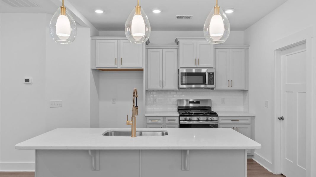 Accomplished kitchen design featuring pendant lighting above a statement island for both prep and gathering in Moore, SC
