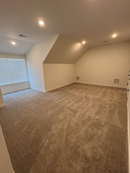 Spacious room featuring new carpeting, recessed lighting, white walls, and a window with blinds Spacious room featuring new carpeting, recessed lighting, white walls, and a window with blinds