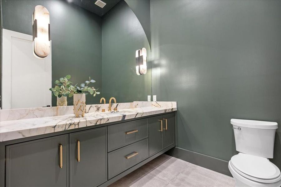 Bathroom featuring toilet, oversized vanity, and tile flooring