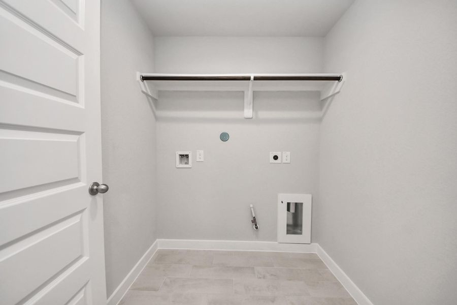 A perfect blend of functionality and comfort. Capture the essence of easy living with a first-floor laundry room, thoughtfully equipped with shelving for effortless organization. Both electric and gas connections available. Sample photo of completed home with similar floor plan. Actual colors and selections may vary. A perfect blend of functionality and comfort. Capture the essence of easy living with a first-floor laundry room, thoughtfully equipped with shelving for effortless organization. Both electric and gas connections available. Sample photo of completed home with similar floor plan. Actual colors and selections may vary.