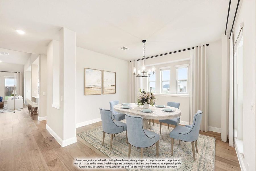 Dining room with oval table, six blue chairs, chandelier, and hardwood floors
