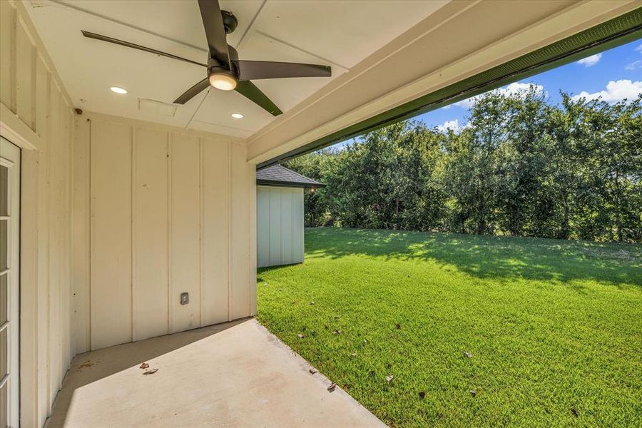 View of green lawn featuring a patio and a ceiling fan View of green lawn featuring a patio and a ceiling fan