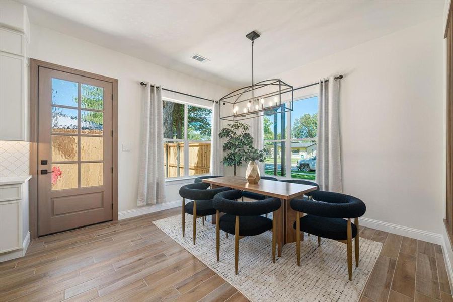 Dining room featuring light wood-style flooring and a chandelier Dining room featuring light wood-style flooring and a chandelier