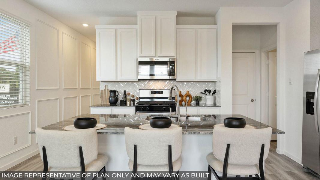 Modern kitchen features a granite island with seating and stainless steel appliances. Modern kitchen features a granite island with seating and stainless steel appliances.