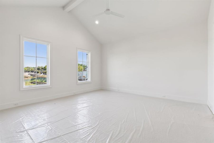 Carpeted bedroom with vaulted ceiling with beams and ceiling fan