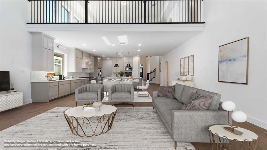 Living room featuring a towering ceiling and light hardwood / wood-style flooring