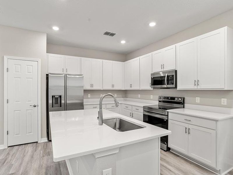 Your new kitchen includes a counter-height island, pantry, and beautiful finishes - Donatella bungalow by Highland Homes