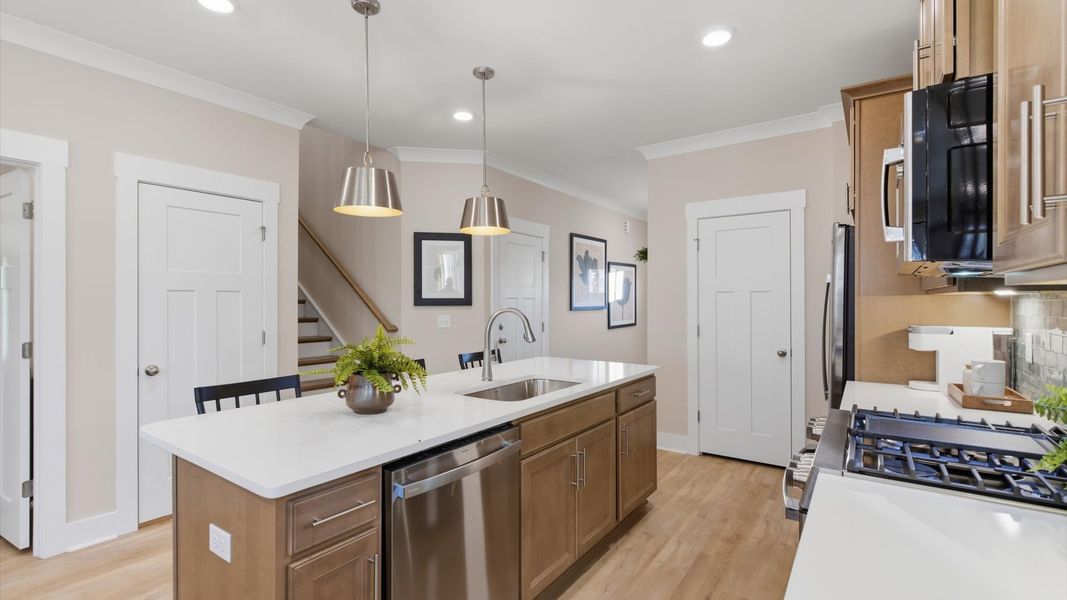 First-rate kitchen with functional layout, designer pendant lighting, and a large center island at Pelham Crossing