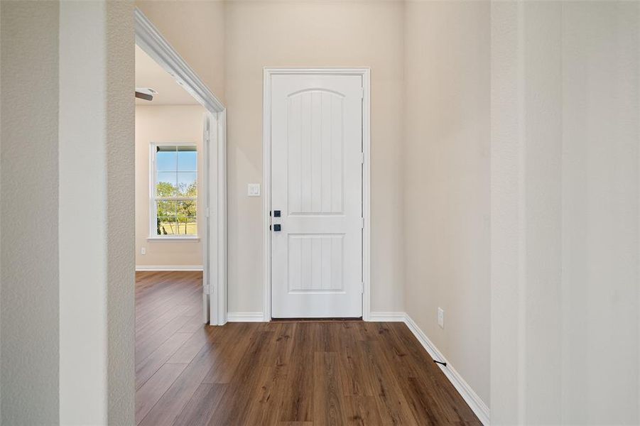 Foyer entrance featuring dark wood-type flooring and baseboards