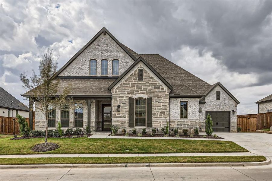 View of front of property featuring a front yard and a garage