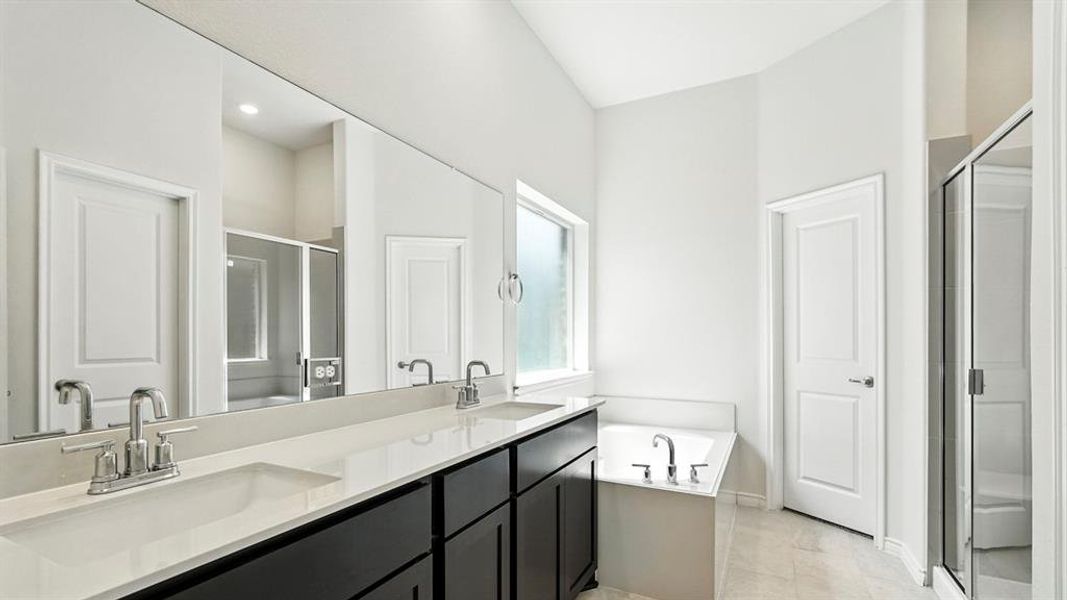 Bathroom with a garden tub, double vanity, and a shower stall