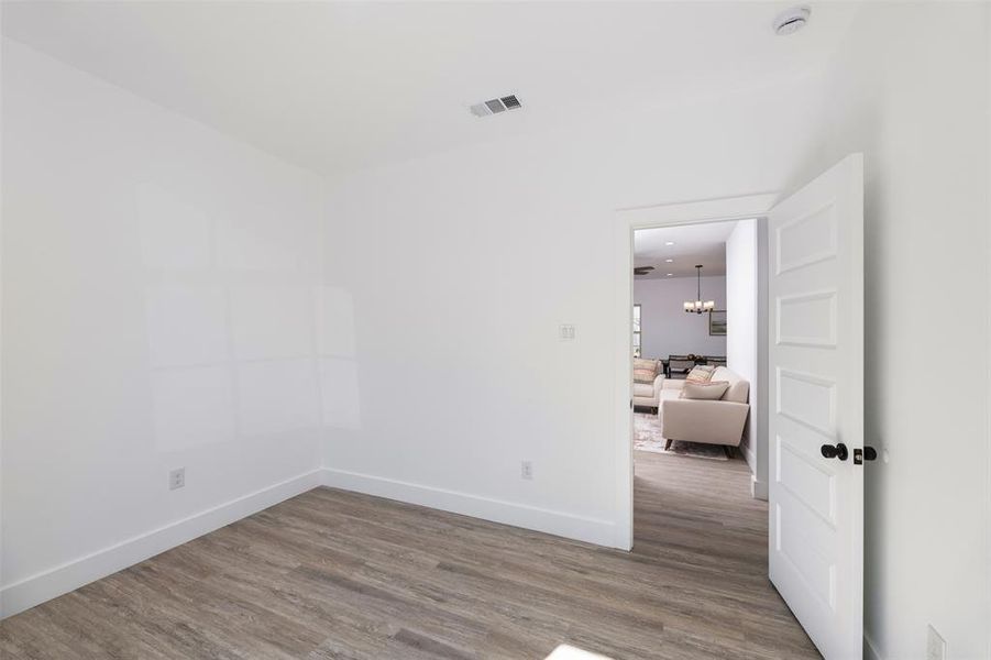 Empty room featuring a chandelier and dark wood-type flooring Empty room featuring a chandelier and dark wood-type flooring