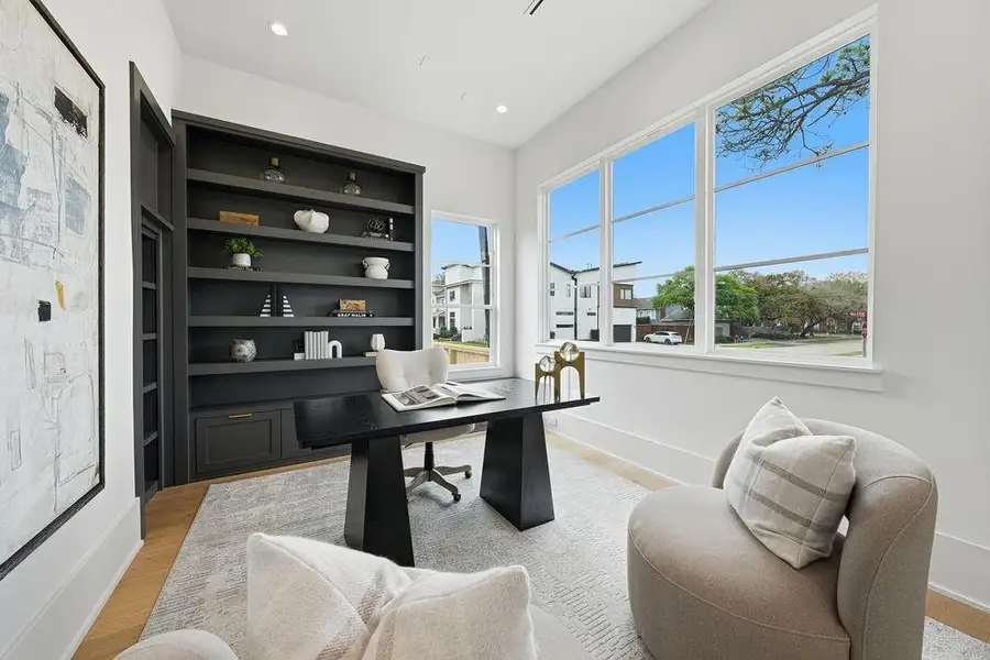 A bright, elegant home office ideal for remote work, meetings, or study, with modern built-ins, large windows, and a calm neutral palette.