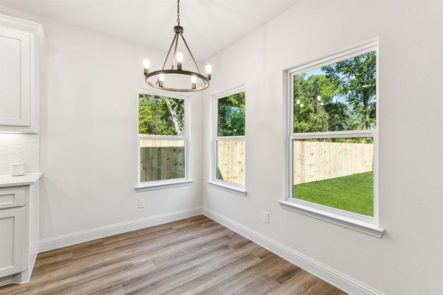 Unfurnished dining area with light wood finished floors and a chandelier