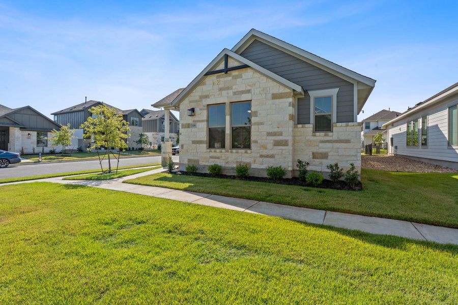 View of front of house featuring stone siding, a front lawn, and a residential view View of front of house featuring stone siding, a front lawn, and a residential view