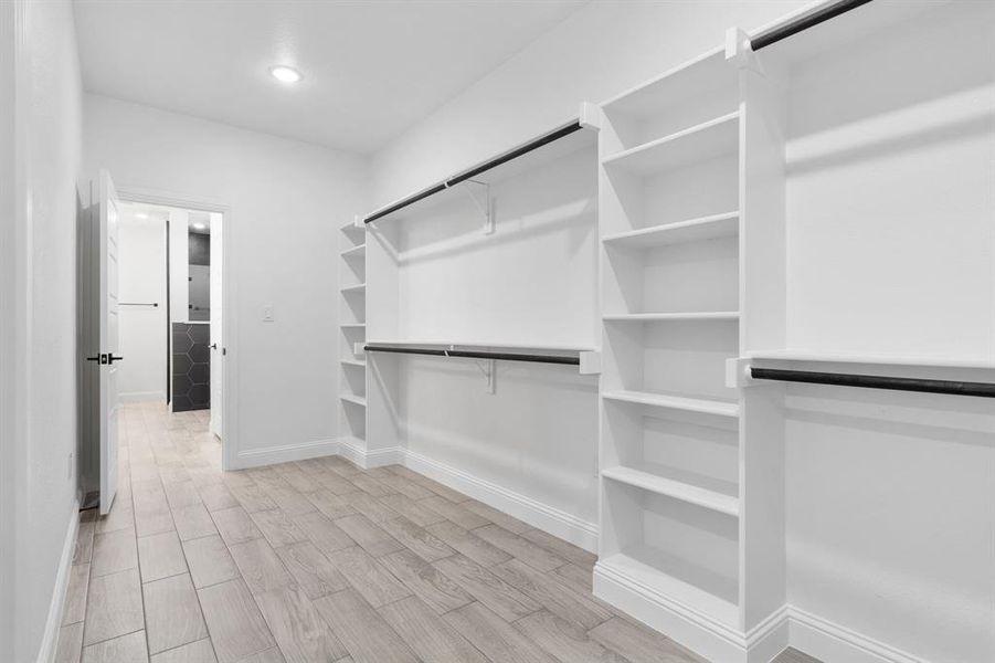 Walk in closet with light wood-type flooring