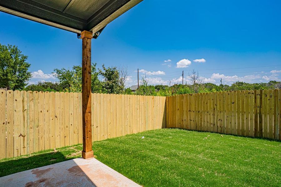 Fenced backyard with covered patio