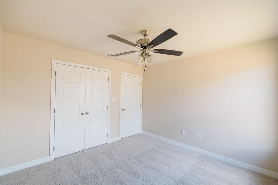 Unfurnished bedroom with carpet, a closet, and ceiling fan Unfurnished bedroom with carpet, a closet, and ceiling fan