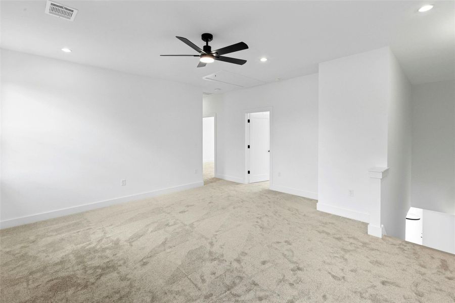 Carpeted spare room with ceiling fan, recessed lighting, and attic access