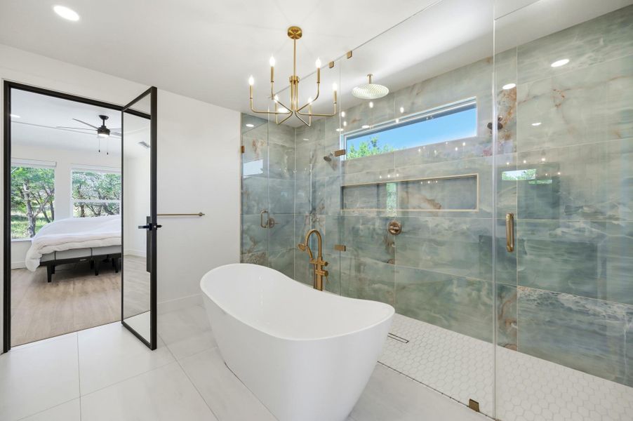 Elegant freestanding tub anchors a modern space highlighted by a glass-enclosed walk-in shower.