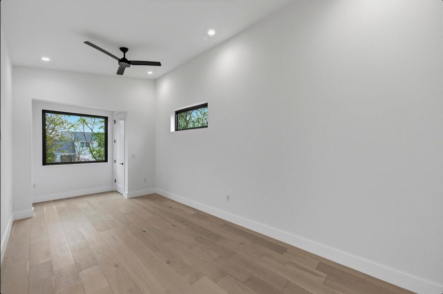 Spare room with light wood finished floors, ceiling fan, recessed lighting, and vaulted ceiling Spare room with light wood finished floors, ceiling fan, recessed lighting, and vaulted ceiling