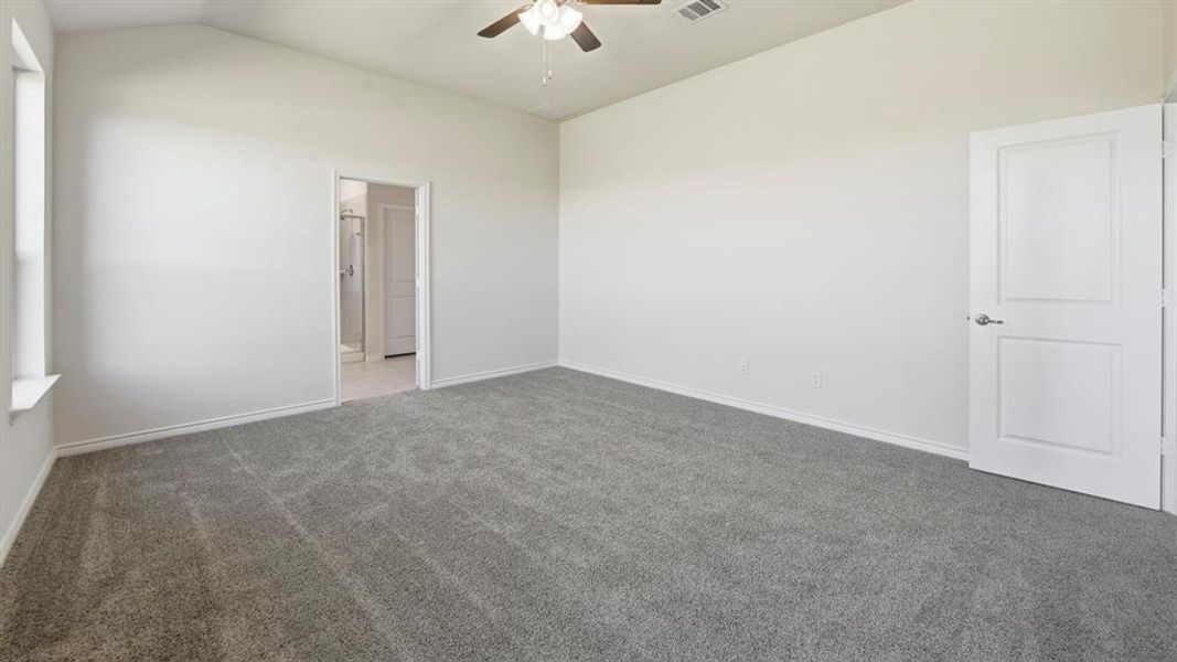 Spare room with vaulted ceiling, carpet flooring, and a ceiling fan Spare room with vaulted ceiling, carpet flooring, and a ceiling fan