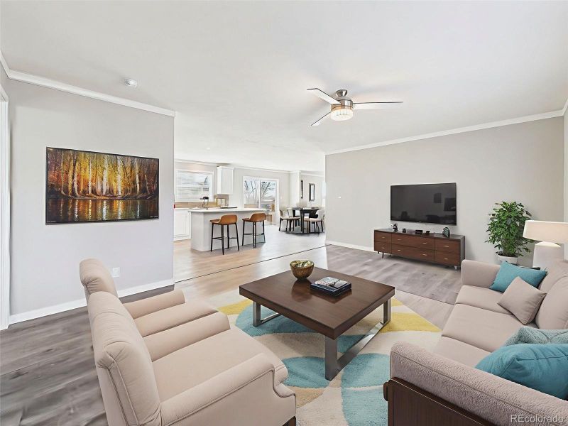 Virtually Staged View to Kitchen – With barstools at the island and a cozy living space nearby, this staging highlights the kitchen’s central role in the home’s open-concept design.