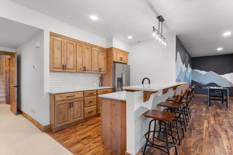 Wet Bar Equipped with a Full Fridge, Dishwasher, and Granite Composite Sink