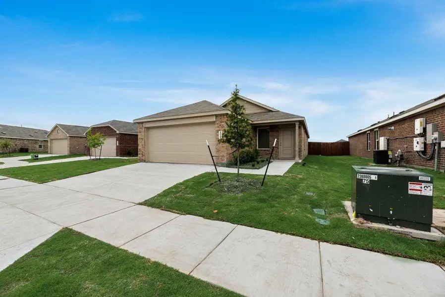View of front of home featuring driveway, brick siding, and an attached garage