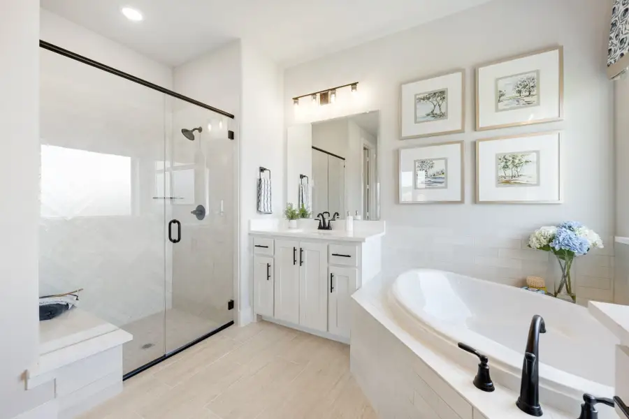 Master bathroom with soaking tub, glass walk-in shower, white vanity, and herringbone tile walls Master bathroom with soaking tub, glass walk-in shower, white vanity, and herringbone tile walls