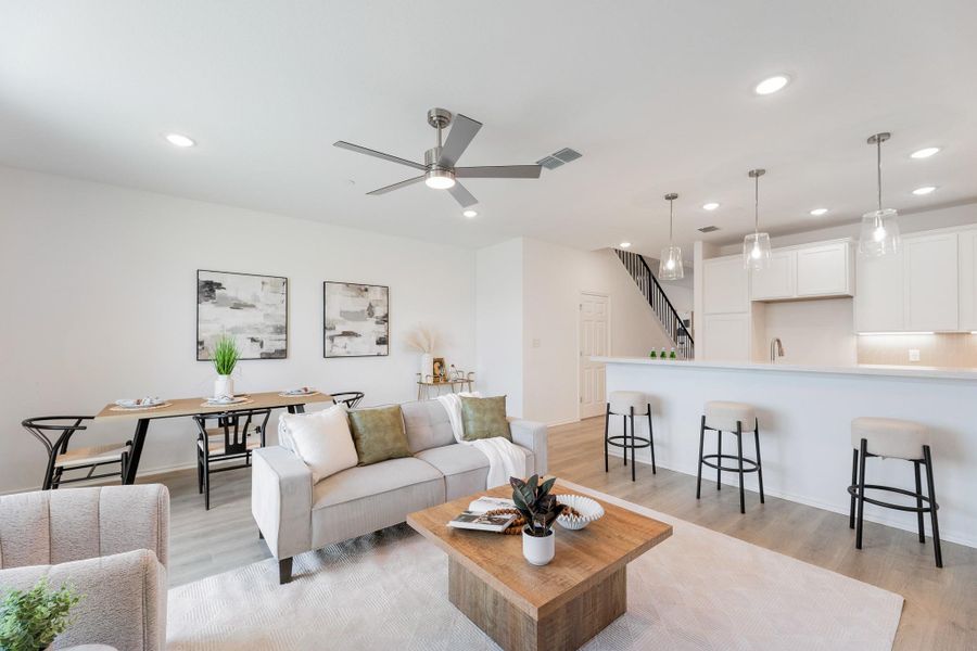 Living area with a ceiling fan, light wood-style flooring, and recessed lighting