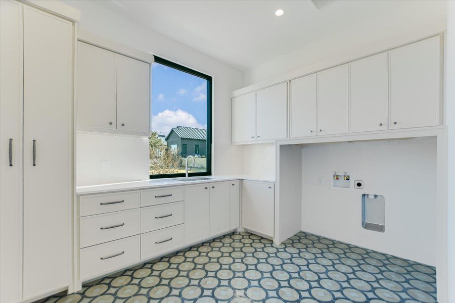 Laundry area with washer hookup, cabinet space, recessed lighting, and light floors